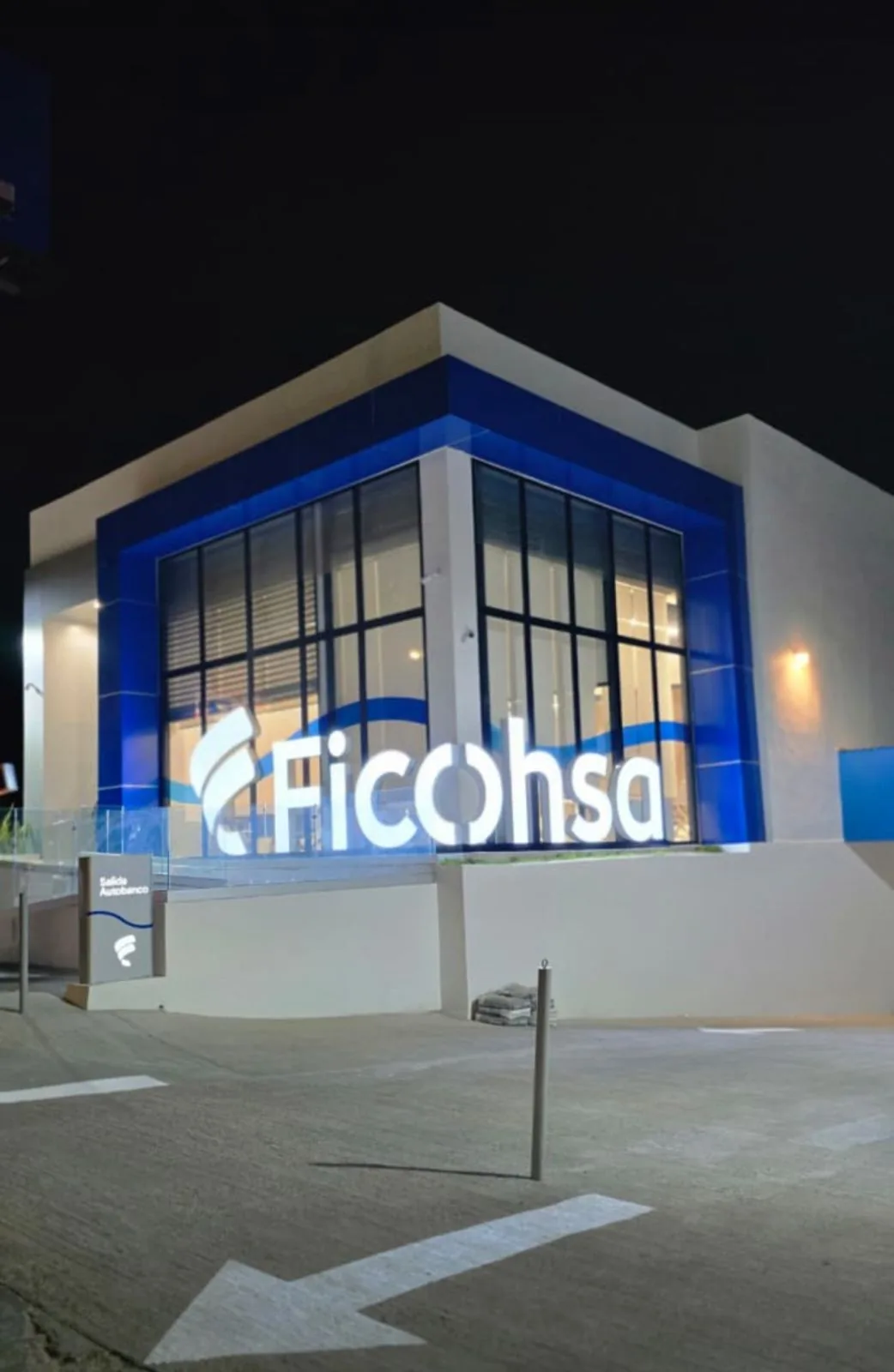 Fachada nocturna Ficohsa Bulevar Suyapa con pintura comercial terminada