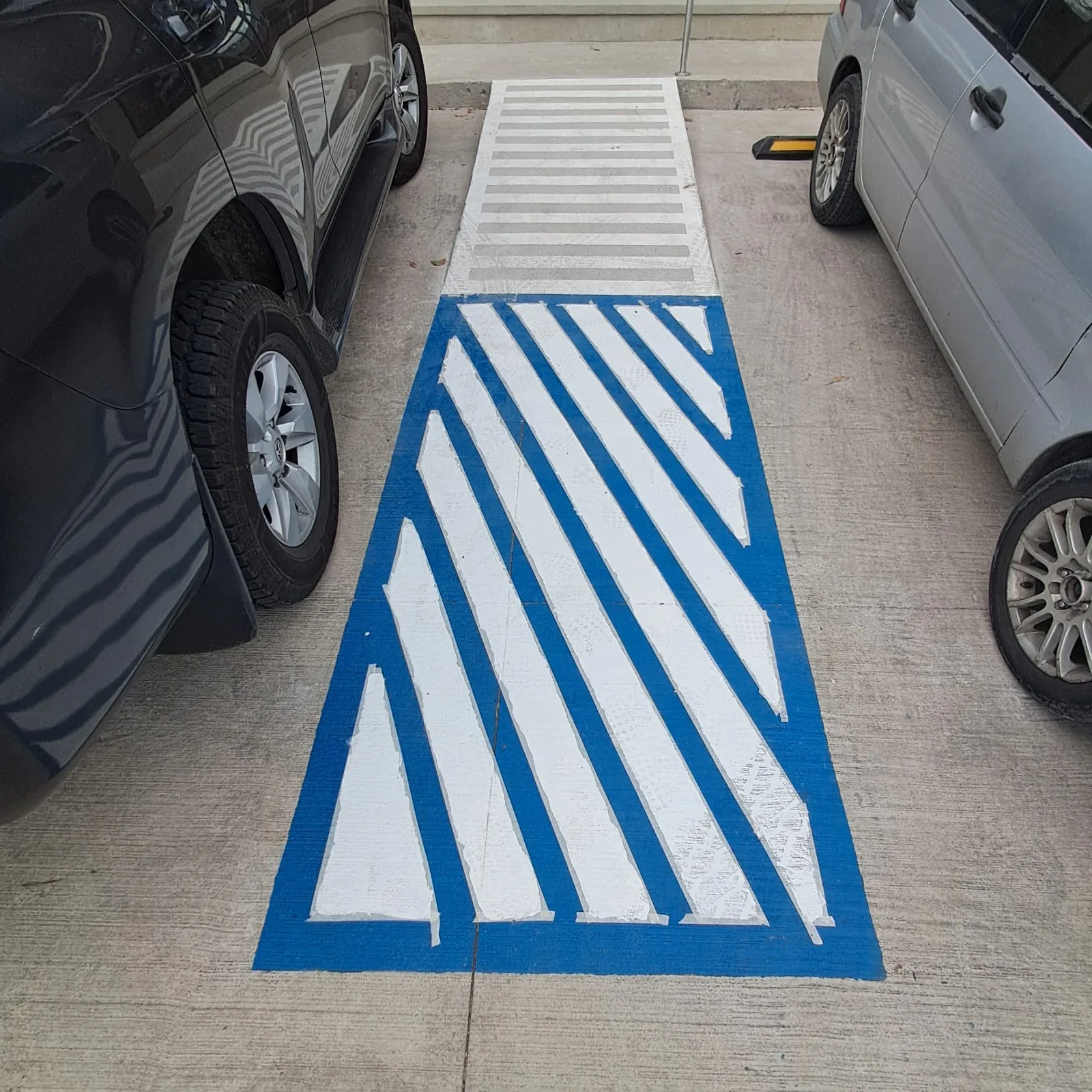 Zona peatonal azul y blanca en estacionamiento comercial